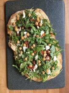 Grilled Thin Crust Pizza with Hummus, Arugula, Sun-dried Tomato, Goat Cheese and Chickpeas